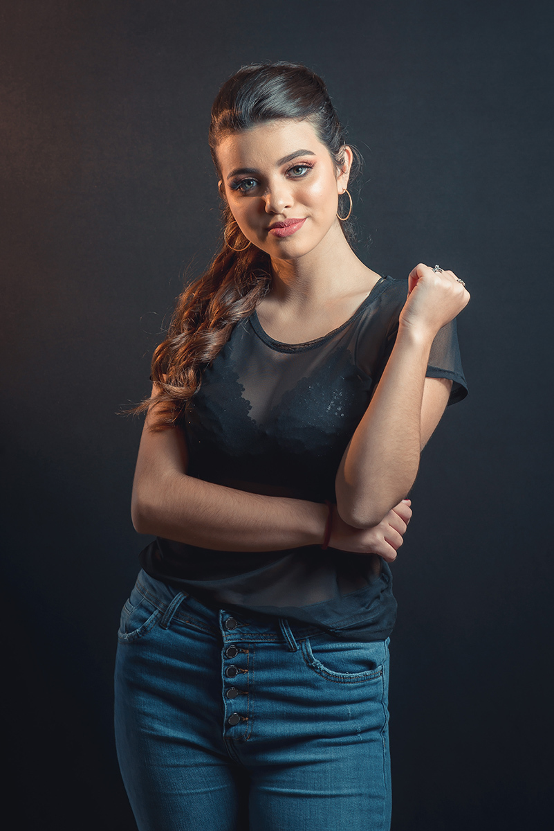Modelo posando em estúdio com fundo preto usando uma blusa preta transparente e calça jeans. Olhos verdes chamando atenção neste lindo editorial de moda em estúdio fotográfico. Foto por Marco Moscarelli Fotógrafo Pelotas.