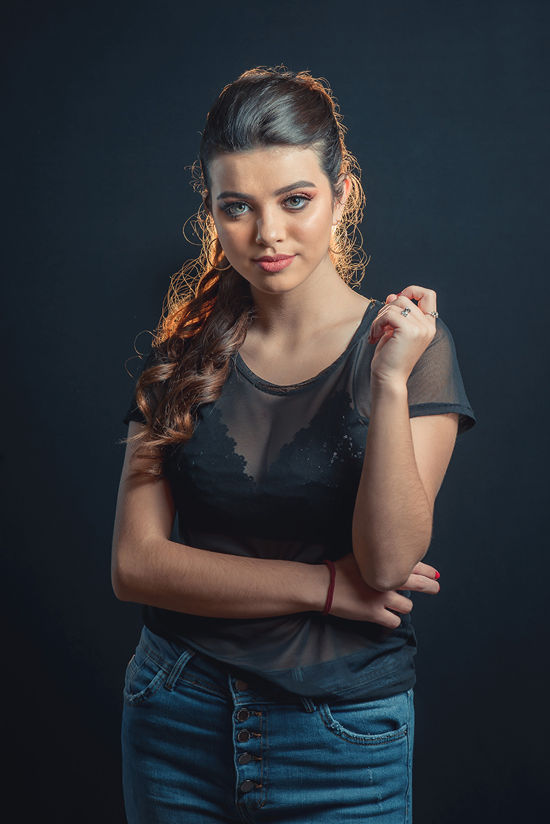 Modelo posando em estúdio com fundo preto usando uma blusa preta transparente e calça jeans. Olhos verdes chamando atenção neste lindo editorial de moda em estúdio fotográfico. Foto por Marco Moscarelli Fotógrafo Pelotas.