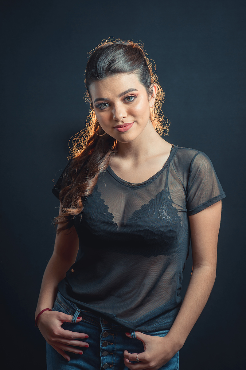Modelo posando em estúdio com fundo preto usando uma blusa preta transparente e calça jeans. Olhos verdes chamando atenção neste lindo editorial de moda em estúdio fotográfico. Foto por Marco Moscarelli Fotógrafo Pelotas.
