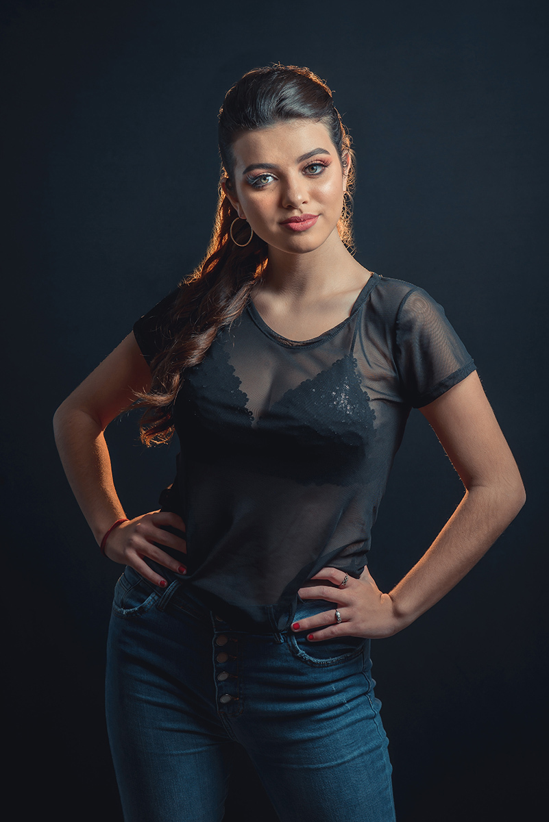 Modelo posando em estúdio com fundo preto usando uma blusa preta transparente e calça jeans. Olhos verdes chamando atenção neste lindo editorial de moda em estúdio fotográfico. Foto por Marco Moscarelli Fotógrafo Pelotas.
