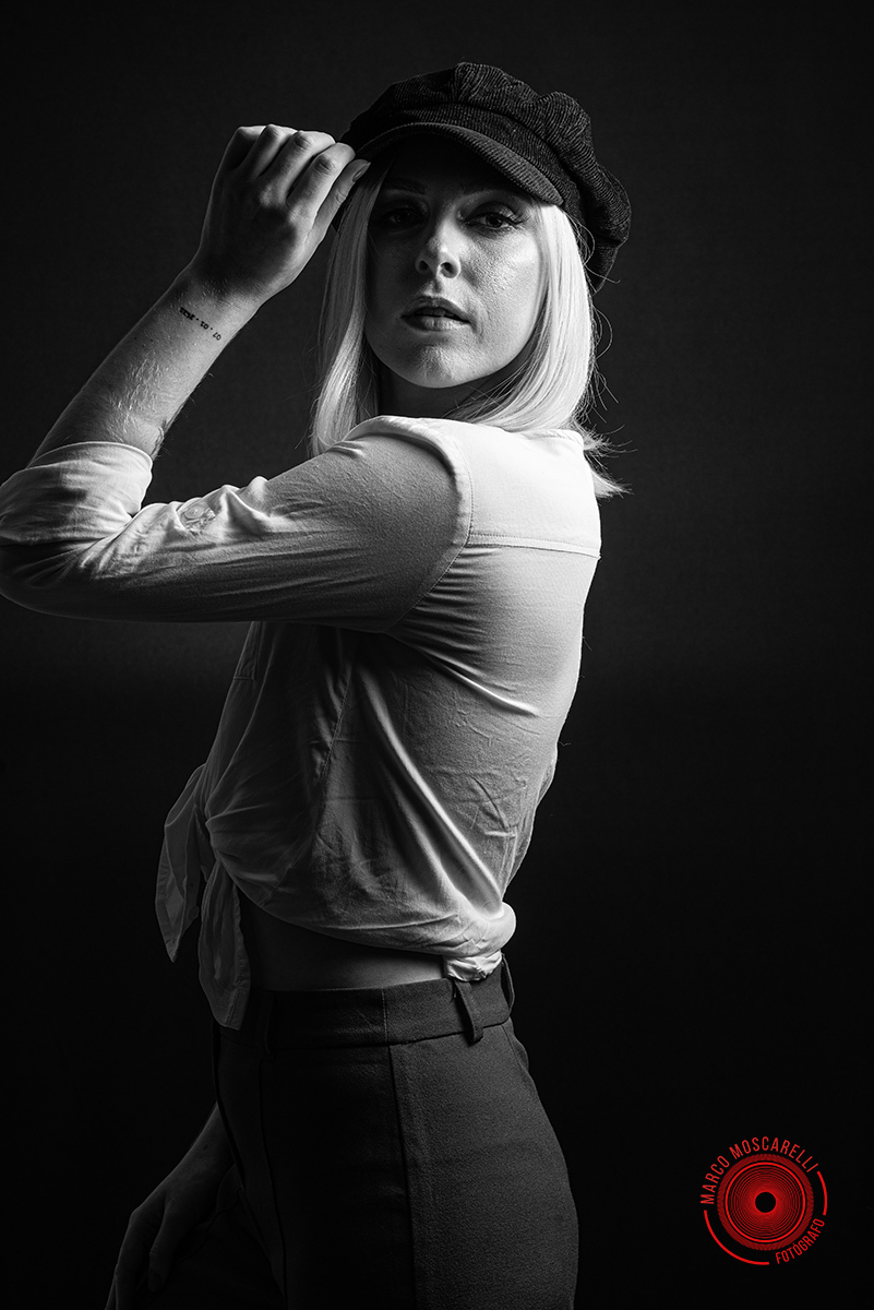 Modelo posando em fundo Preto usando uma calça vermelha e blusinha branca em editorial de moda em estúdio fotográfico. Foto por Marco 