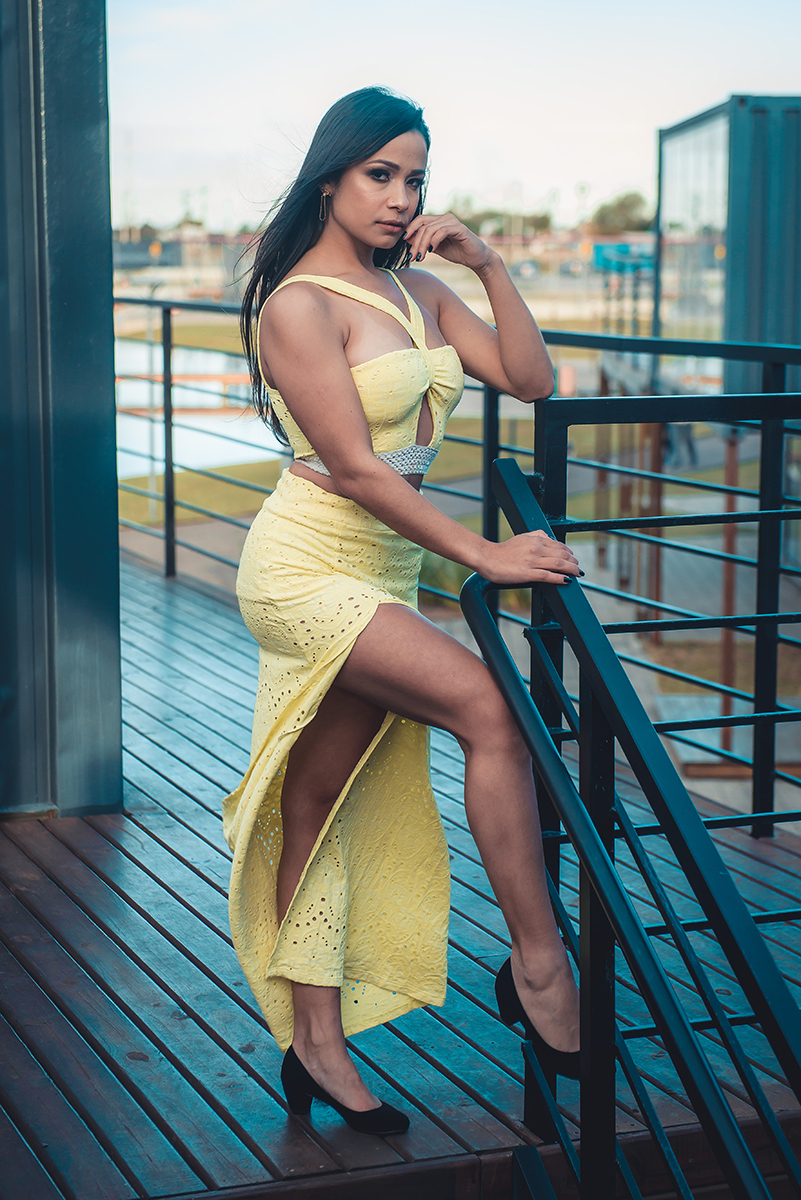 Modelo posando posando para foto usando um belo vestido amarelo apoiada em escada  em ensaio fotográfico realizado no parque Una em Pelotas. Foto por Marco Moscarelli Fotógrafo Pelotas.