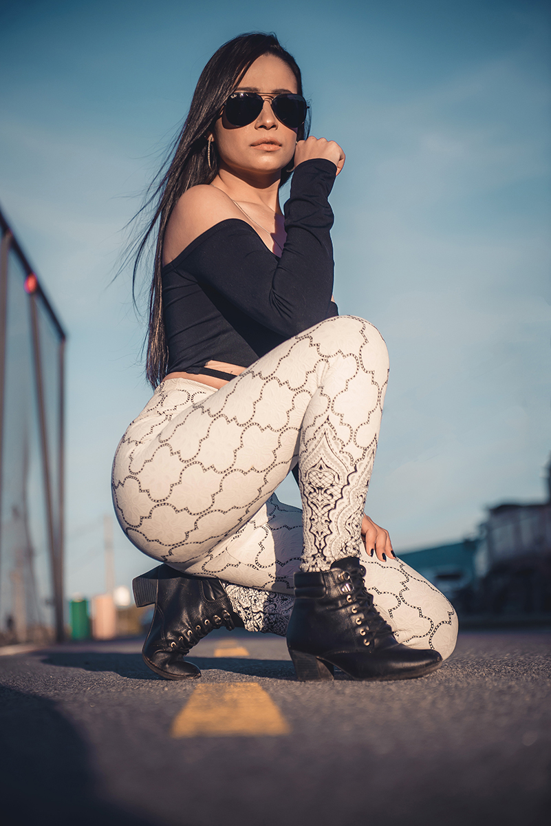 Modelo posando  encostada em tela de quadra de esportes, usando roupas despojadas  em ensaio fotográfico realizado no parque Una em Pelotas. Foto por Marco Moscarelli Fotógrafo Pelotas.