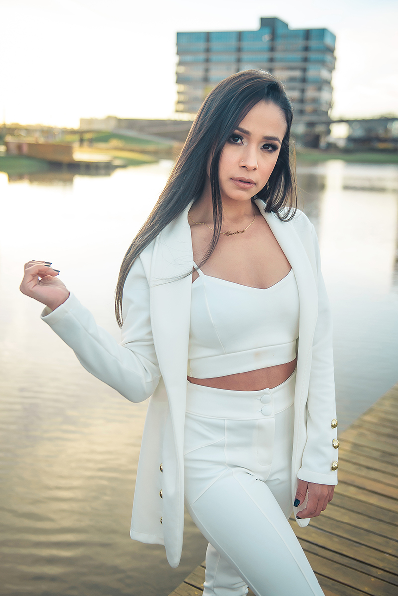 Modelo posando  usando um terninho branco para fotografia com o fundo desfocado em ensaio fotográfico realizado no parque Una em Pelotas. Foto por Marco Moscarelli Fotógrafo Pelotas.