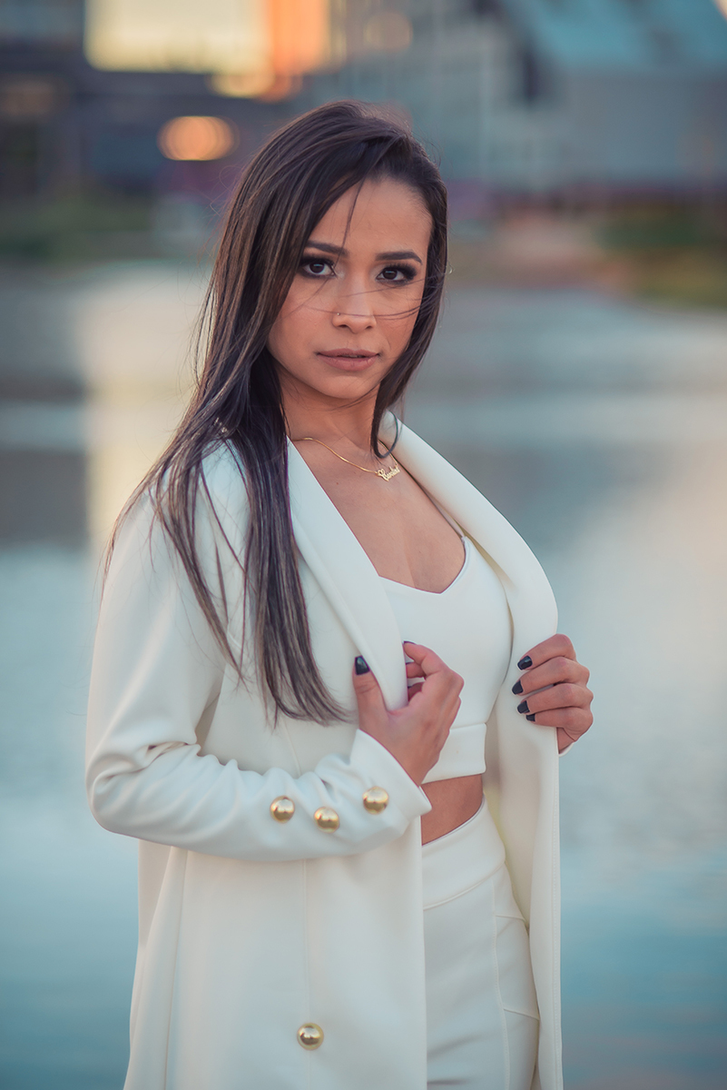 Modelo posando  usando um terninho branco para fotografia com o fundo desfocado em ensaio fotográfico realizado no parque Una em Pelotas. Foto por Marco Moscarelli Fotógrafo Pelotas.