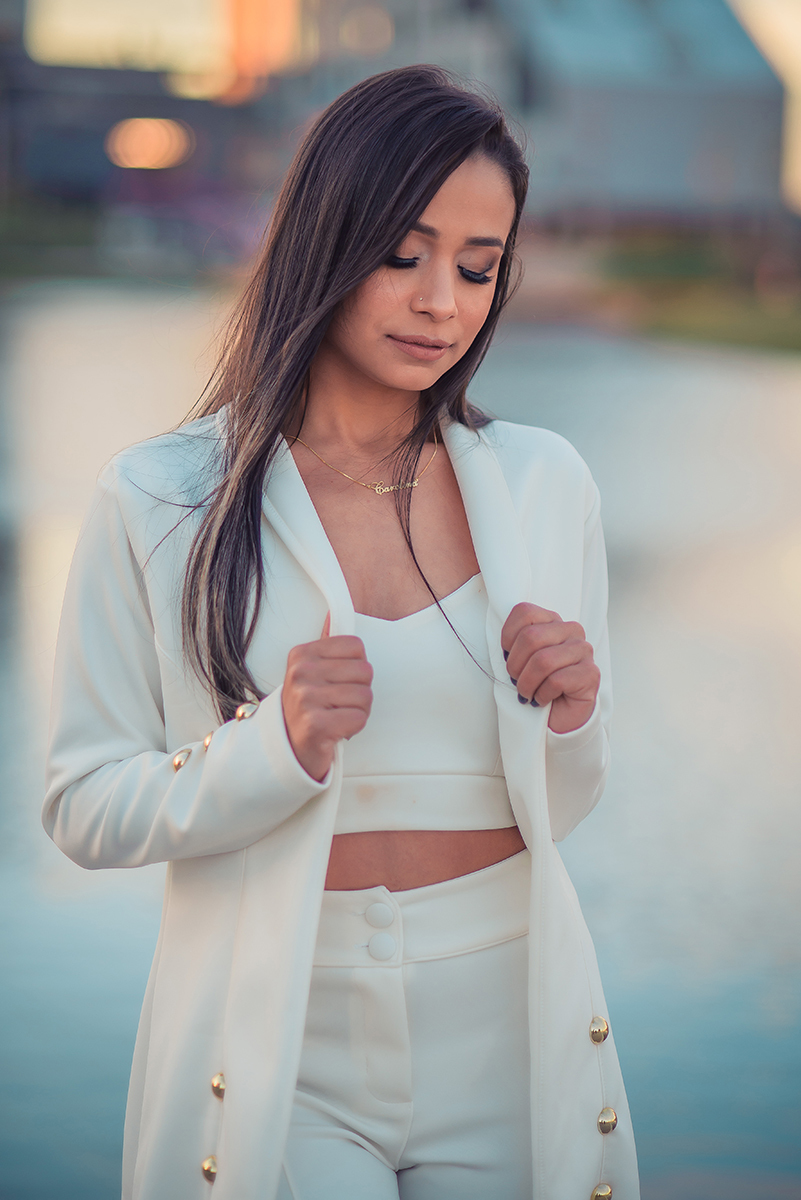Modelo posando  usando um terninho branco para fotografia com o fundo desfocado em ensaio fotográfico realizado no parque Una em Pelotas. Foto por Marco Moscarelli Fotógrafo Pelotas.