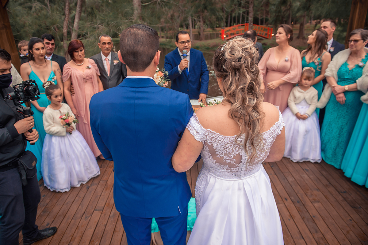 Noivos no altar do casamento em fotografia por tras e pelo alto durante a celebração do casamento pelo pastor. Foto por Marco Moscarelli Fotógrafo Pelotas.
