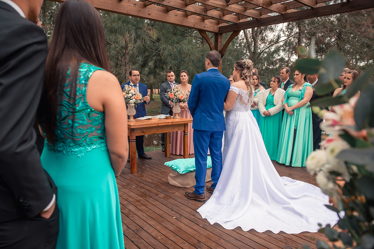 Noivos no altar do casamento em fotografia por tras e pelo alto durante a celebração do casamento pelo pastor. Foto por Marco Moscarelli Fotógrafo Pelotas.