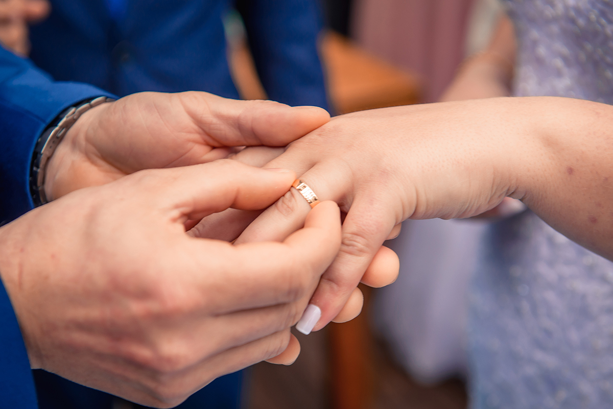 Noivo colocando a aliança no dedo da noiva durante a cerimônia de casamento. Foto por Marco Moscarelli Fotógrafo Pelotas.