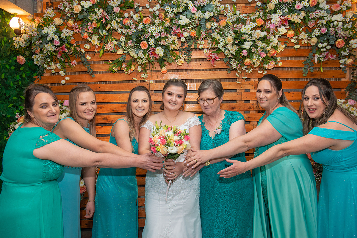 Madrinhas confraternizando com a noiva, tentando pegar o buquê da noiva após o casamento. Foto por Marco Moscarelli Fotógrafo Pelotas.