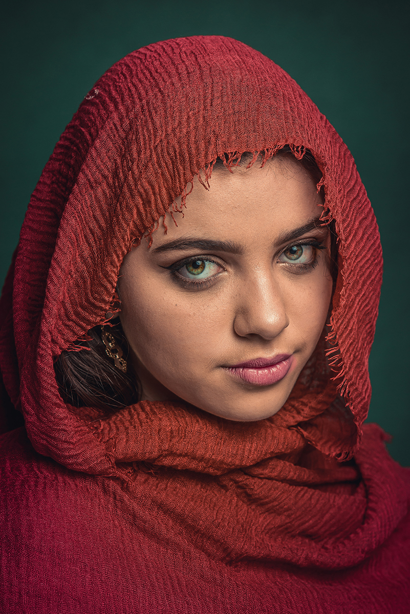 Linda reprodução de fotografia de Steve McCurry. Modelo usando lenço vermelho no rosto com fundo verde. Foto por Marco Moscarelli Fotógrafo Pelotas.
