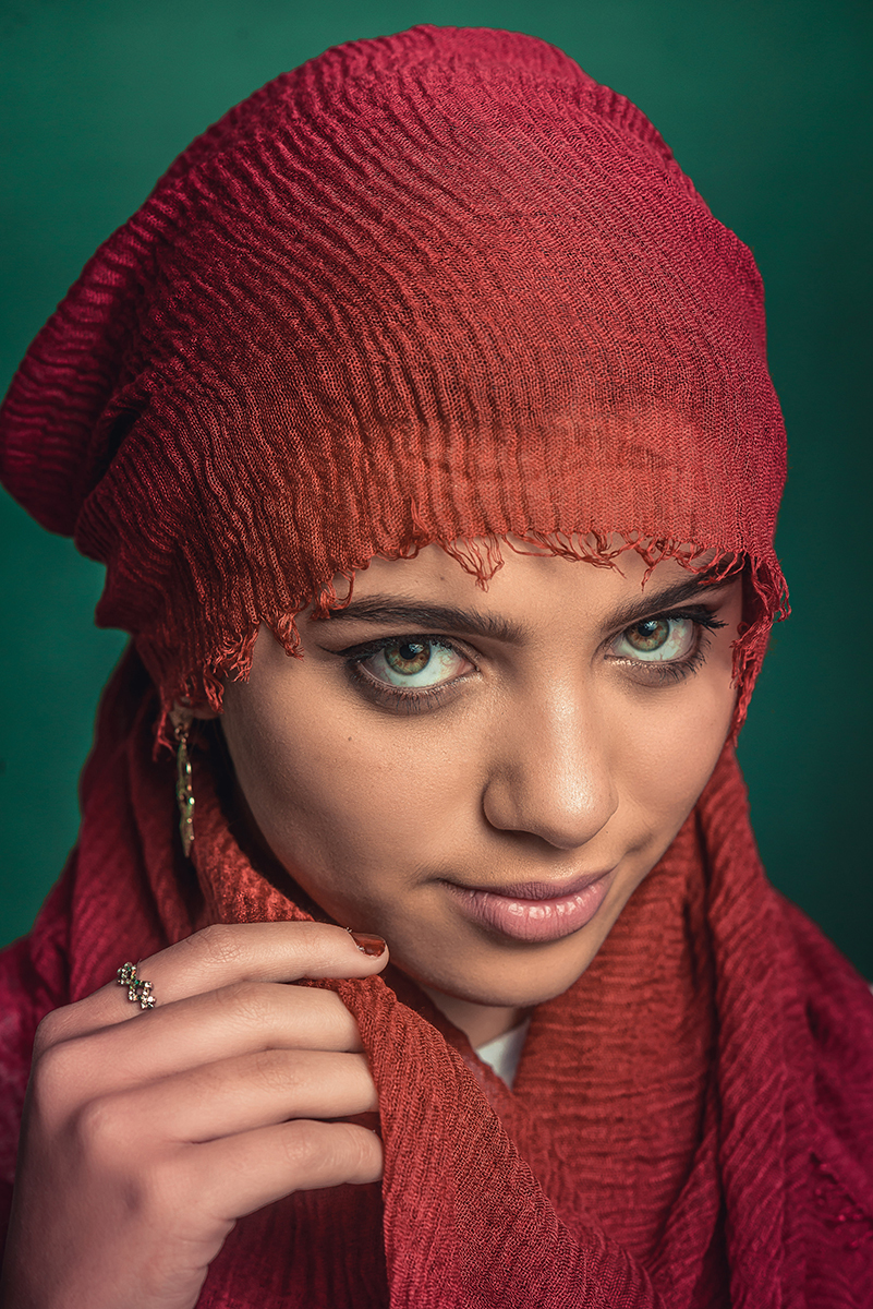 Linda reprodução de fotografia de Steve McCurry. Modelo usando lenço vermelho no rosto com fundo verde. Foto por Marco Moscarelli Fotógrafo Pelotas.