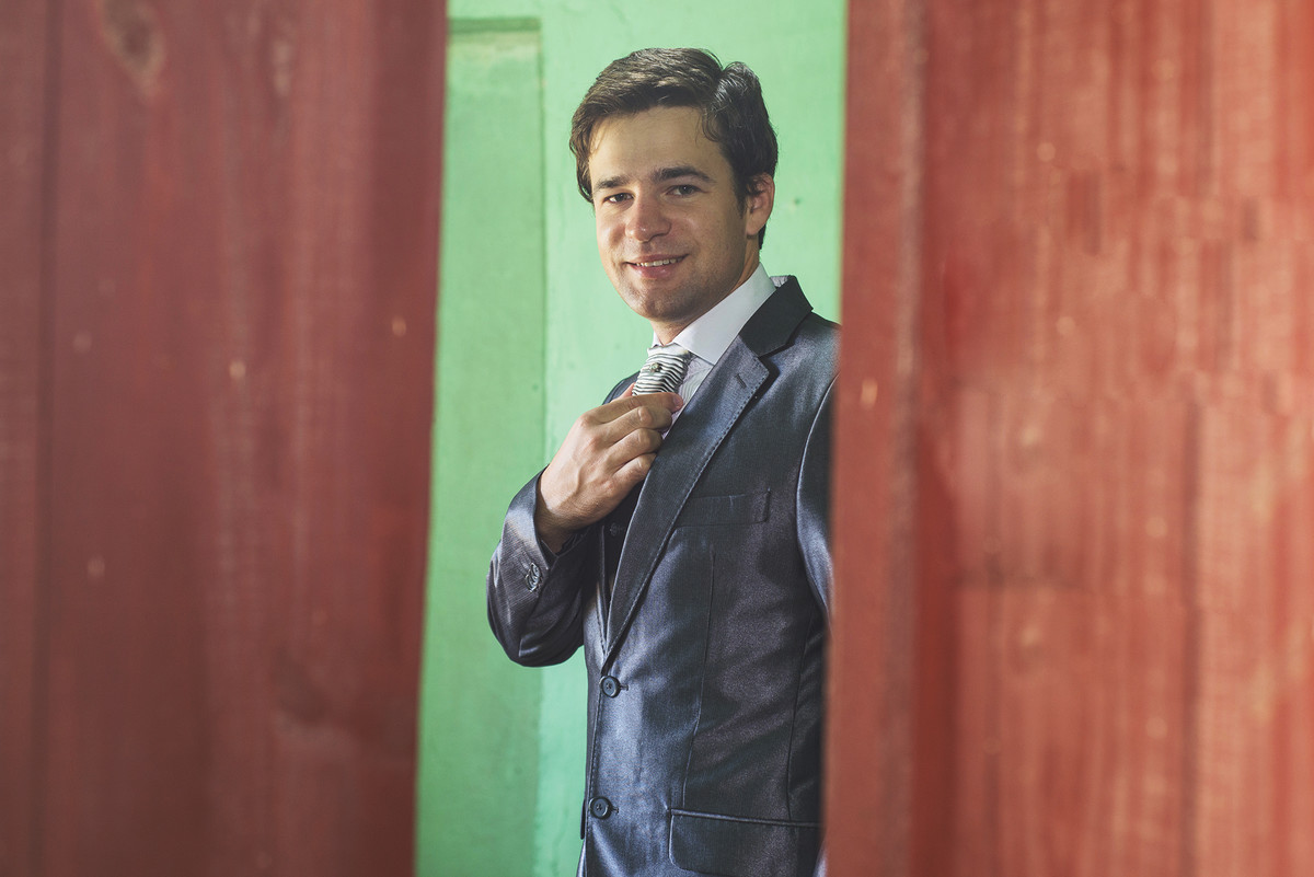 Detalhe do noivo abotoando a manga da camisa  para o casamento