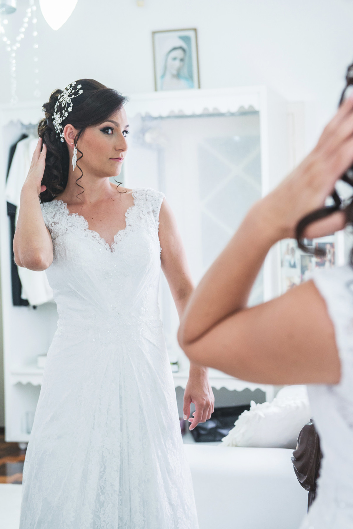 Noiva conferindo o vestido na frente do espelho antes da cerimônia de casamento.