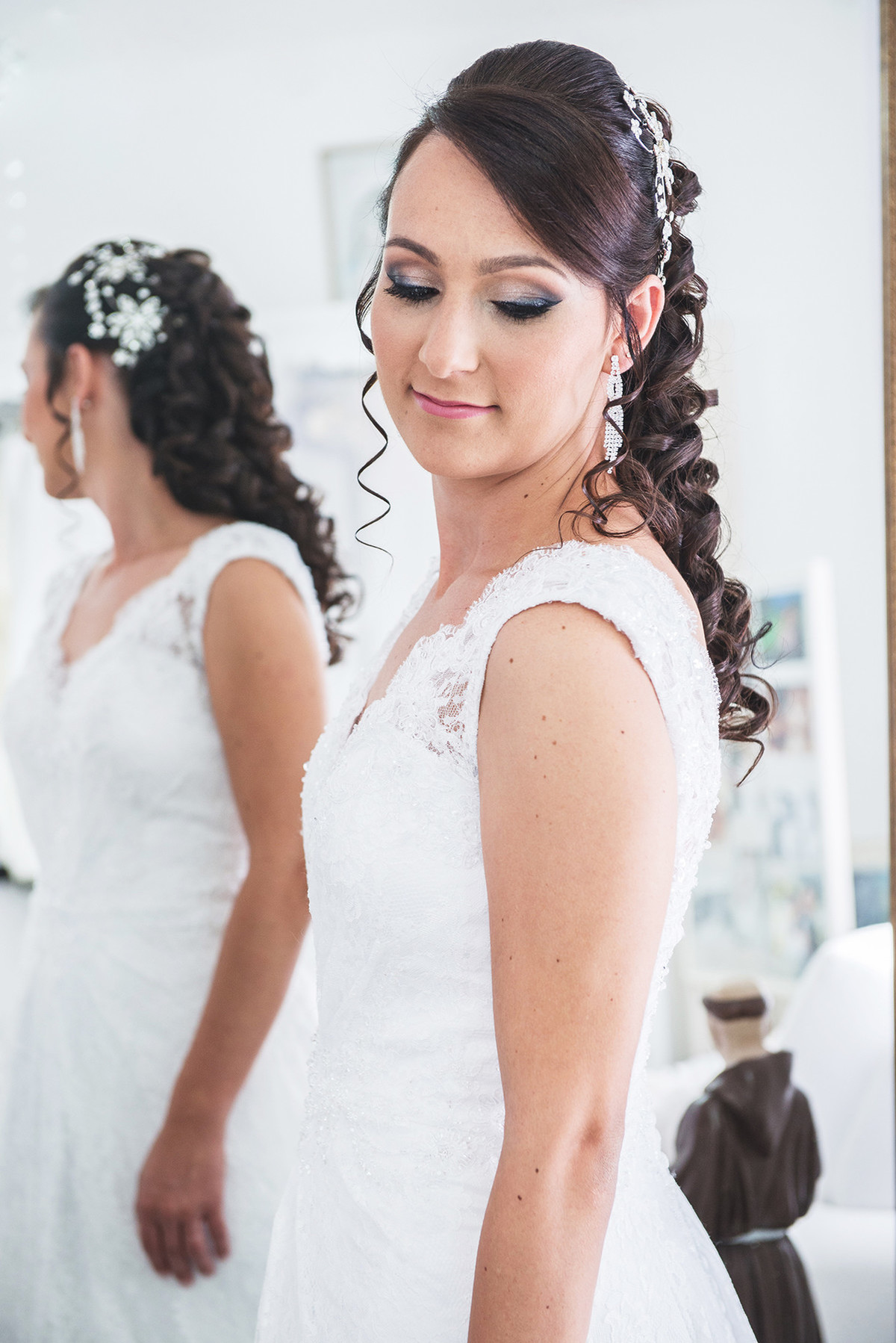 Noiva conferindo o vestido na frente do espelho antes da cerimônia de casamento.