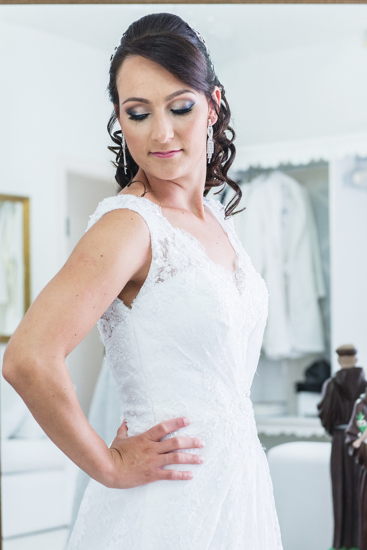Noiva conferindo o vestido na frente do espelho antes da cerimônia de casamento.
