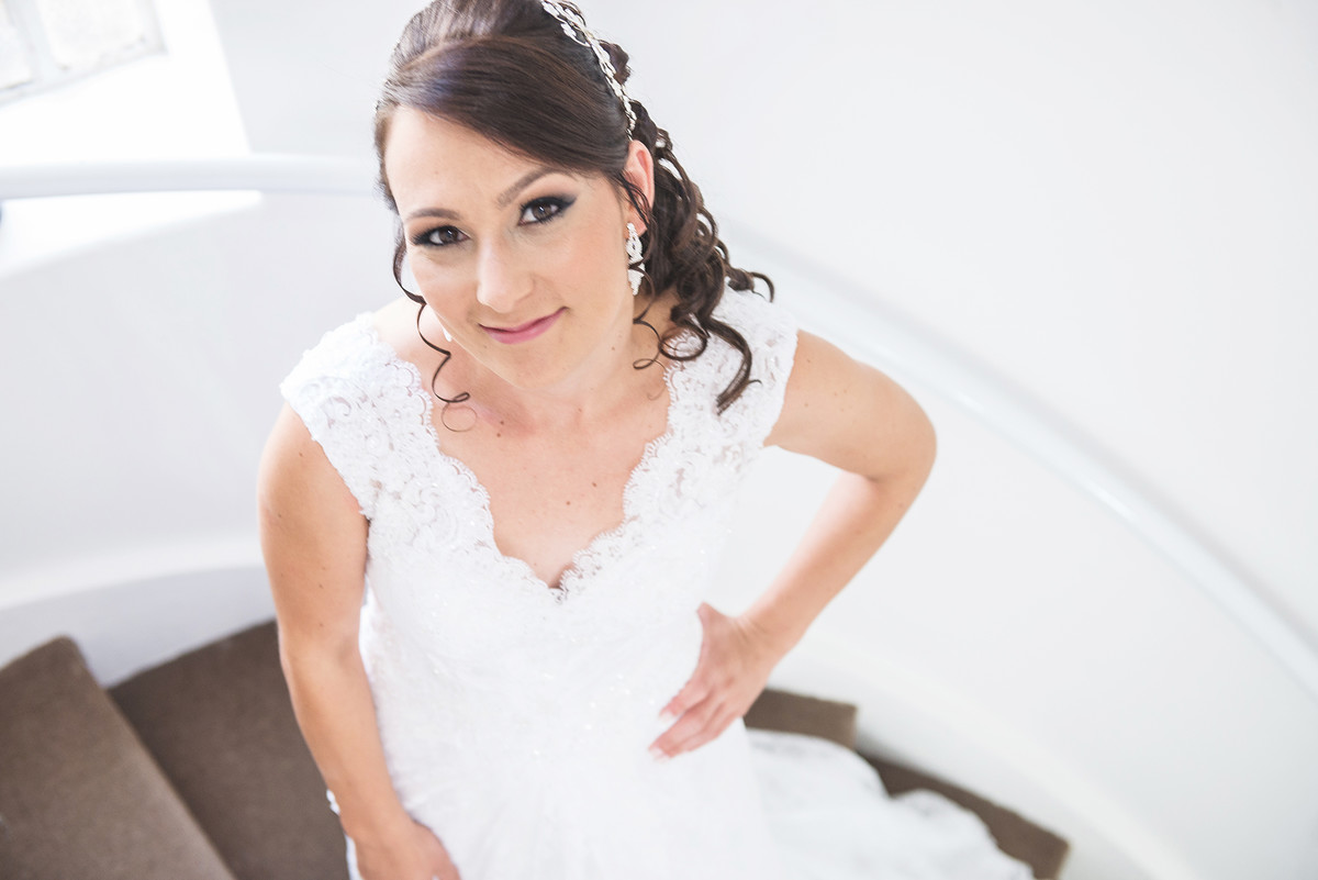 Noiva conferindo o vestido na frente do espelho antes da cerimônia de casamento.