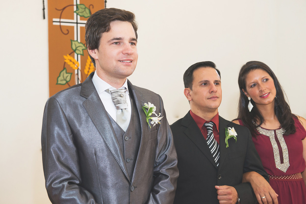 Sorriso do noivo ao ver a noiva entrando na igreja no momento do casamento.