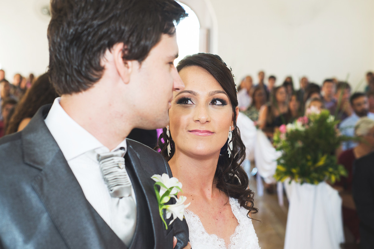 Noiva dando um olhar singelo para o noivo no momento da cerimônia de casamento.