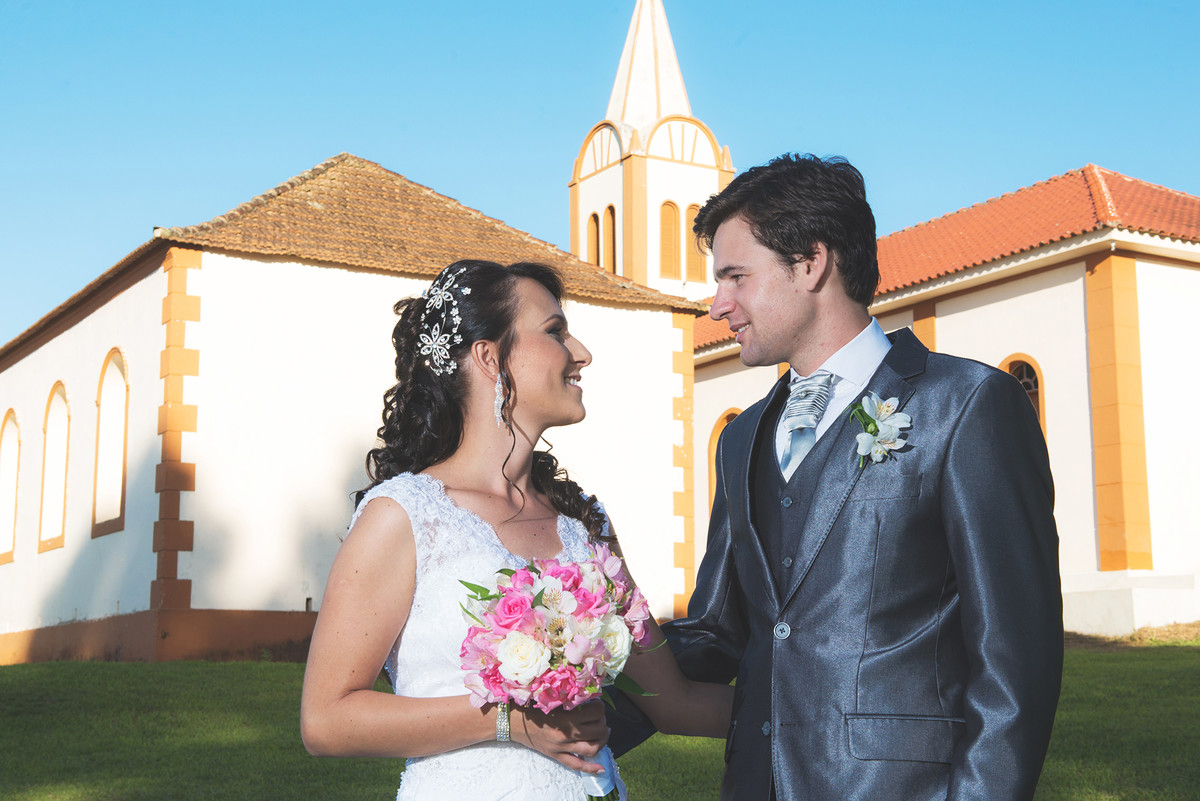 Fotos dos noivos com a igreja ao fundo.