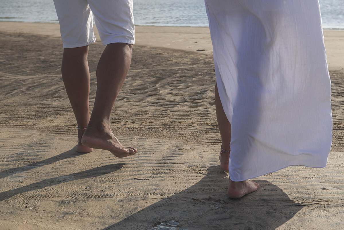 Foto em detalhe dos pés dos noivos caminhando pela praia durante seu ensaio de casal pré wedding. ensaio de casal na praia da caiplha. Foto por Marco Moscarelli Fotógrafo