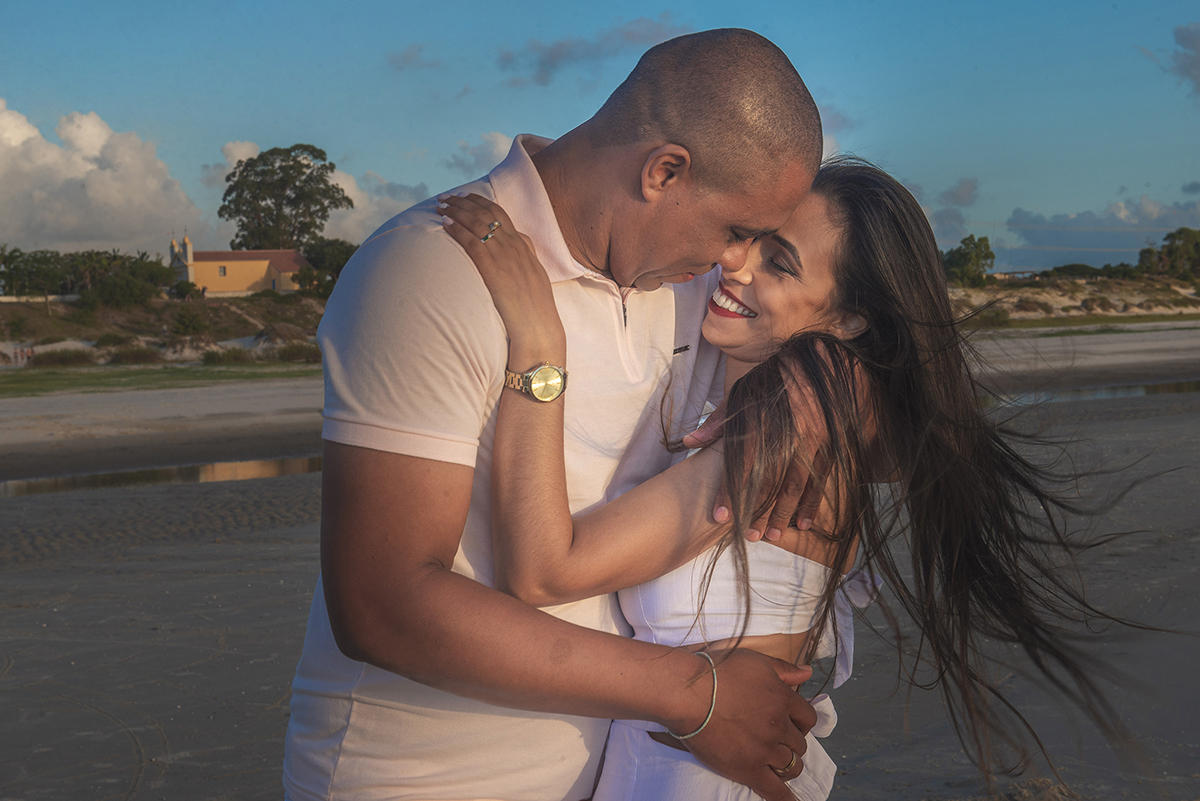Casal em momento lindo ao por do sol  durante seu ensaio de casal na praia da caiplha. Foto por Marco Moscarelli Fotógrafo Pelotas. 