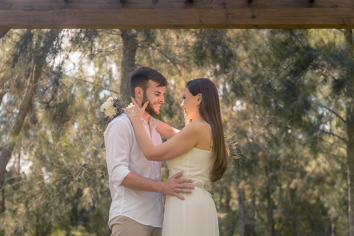 Momento do casal em meio a natureza trocando olhares e sorrisos  durante seu ensaio pré wedding no seu pré casamento na chácara Fiss. Foto por Marco Moscarelli Fotógrafo Pelotas.