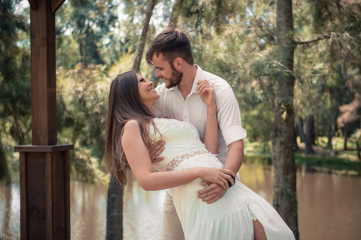 Pose do casal de noivos noiva e noivo dançando a noiva deitada nos braços do noivo  durante seu ensaio pré wedding no seu pré casamento na chácara Fiss. Foto por Marco Moscarelli Fotógrafo Pelotas.