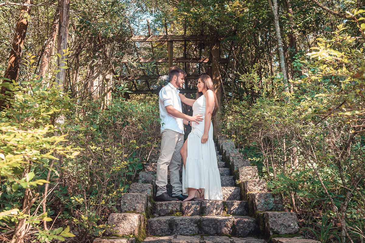 Linda fotos do casal de noivos em uma escadaria em meio a natureza durante seu ensaio pré wedding no seu pré casamento na chácara Fiss. Foto por Marco Moscarelli Fotógrafo Pelotas.