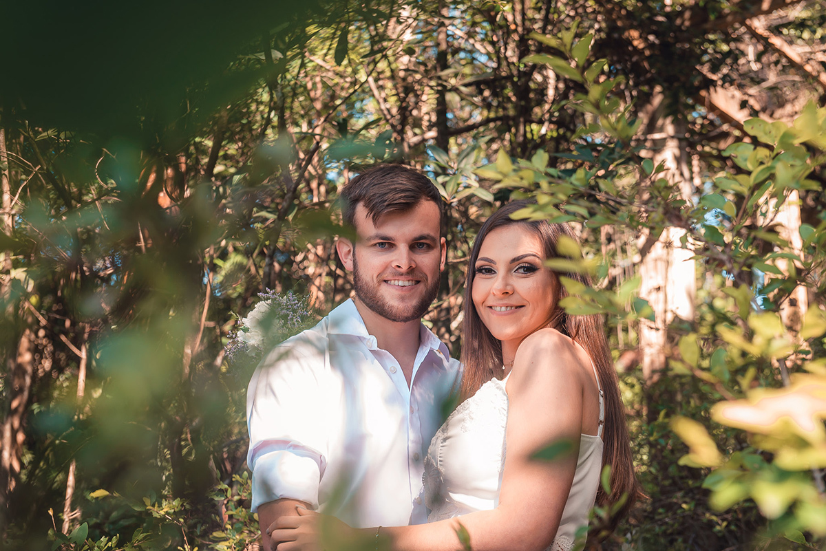 Casal de noivos posando para fotos em meio a natureza durante seu ensaio pré wedding no seu pré casamento na chácara Fiss. Foto por Marco Moscarelli Fotógrafo Pelotas.