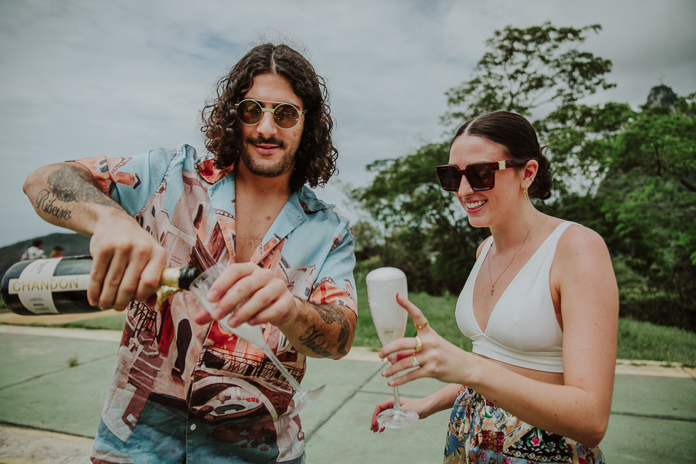
Bride gets emotional with surprise marriage proposal at Dona Marta viewpoint, one of the most beautiful places in the city of Rio de Janeiro, which has views of Cristo Redentor and Sugar Loaf, engagement ring, wedding ring RJ, noivado champagne