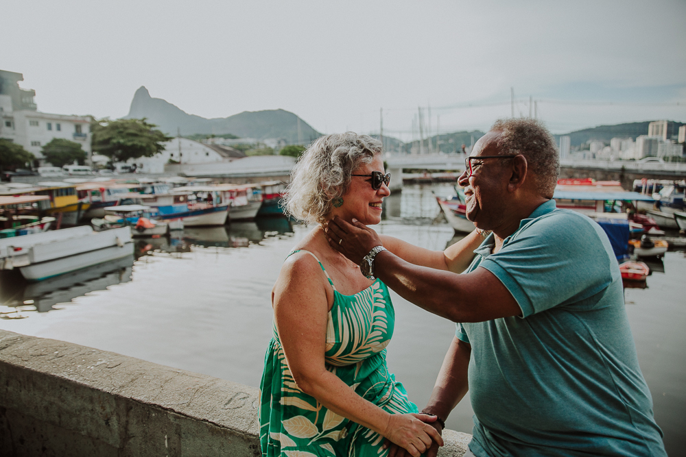  Fotografia afetiva de casal maduro sorrindo e trocando carinho na Mureta da Urca, RJ.
