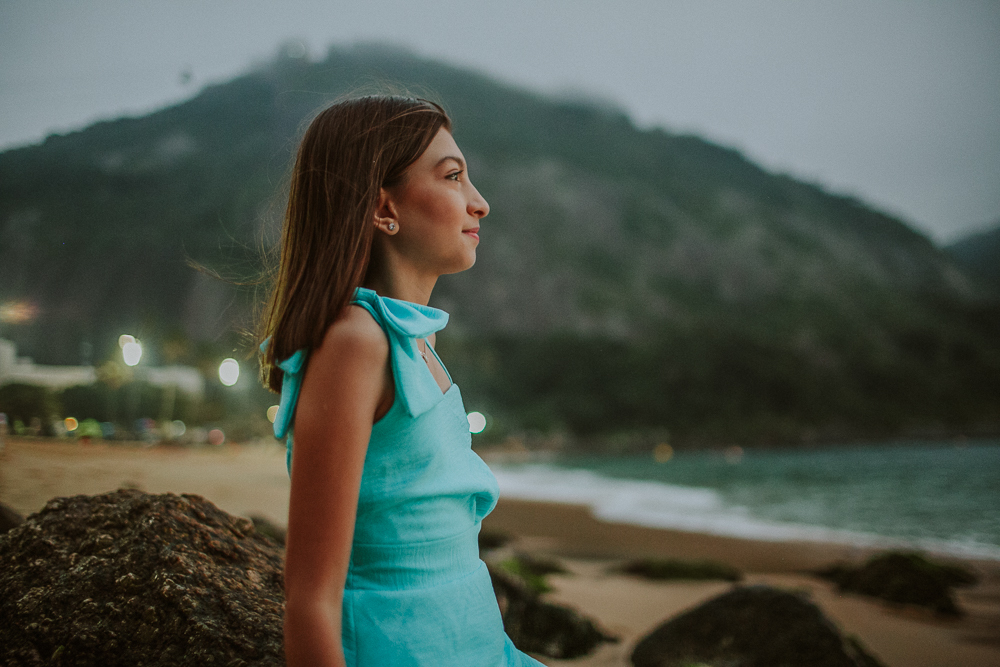 Menina observando o mar durante ensaio fotográfico de família.