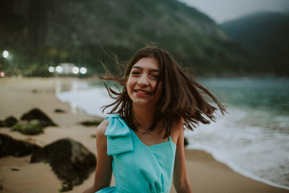 Retrato espontâneo de menina sorrindo na Praia Vermelha durante um ensaio fotografico
