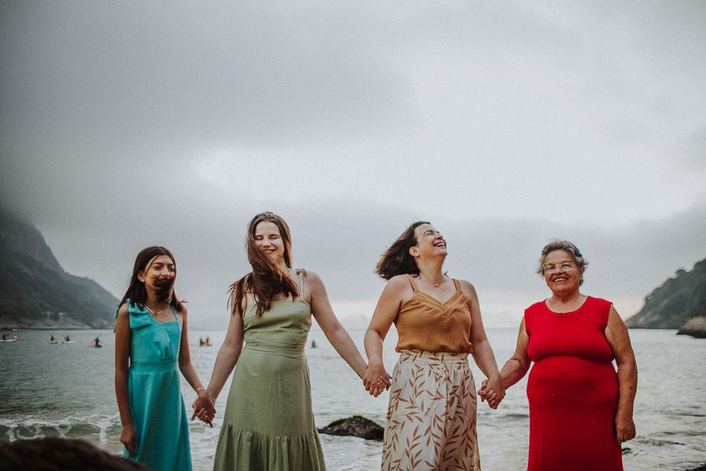 Três gerações caminhando juntas na Praia Vermelha durante um ensaio fotografico de familia RJ