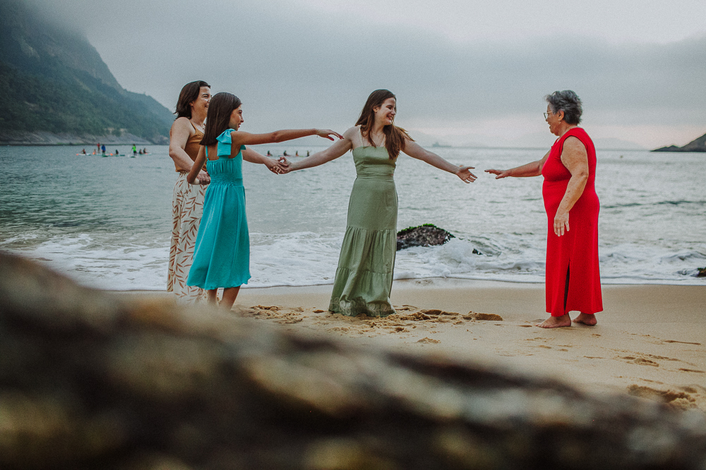 Família brincando de mãos dadas na Praia Vermelha.
