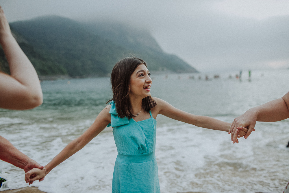 Menina sorrindo durante ensaio fotográfico de família.