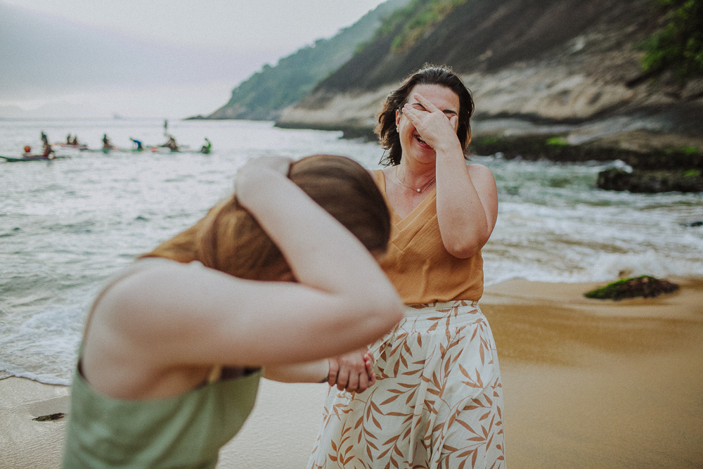 Mãe e filha rindo muito durante ensaio fotográfico na Praia Vermelha.
