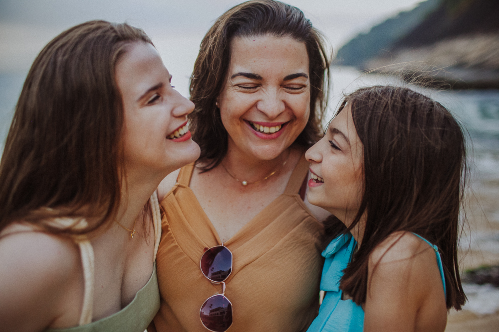 Retrato espontâneo de mãe e filhas durante ensaio de família na Praia Vermelha.