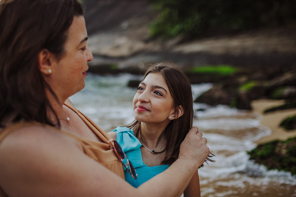 Mãe abraçando a filha durante ensaio fotográfico.