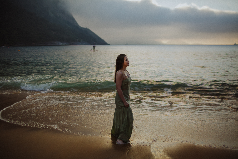Mulher contemplando o mar durante ensaio fotográfico feminino.