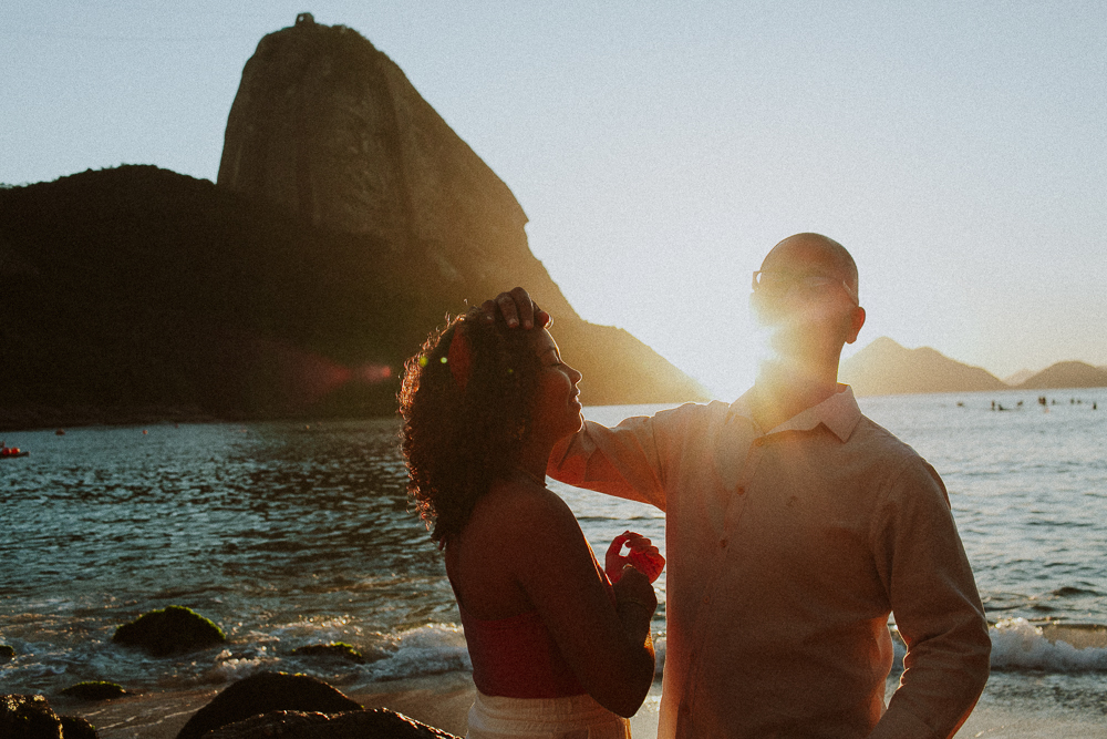Alice e seu pai durante a bênção de 15 anos na Praia Vermelha, fotografados em silhueta diante do Pão de Açúcar.