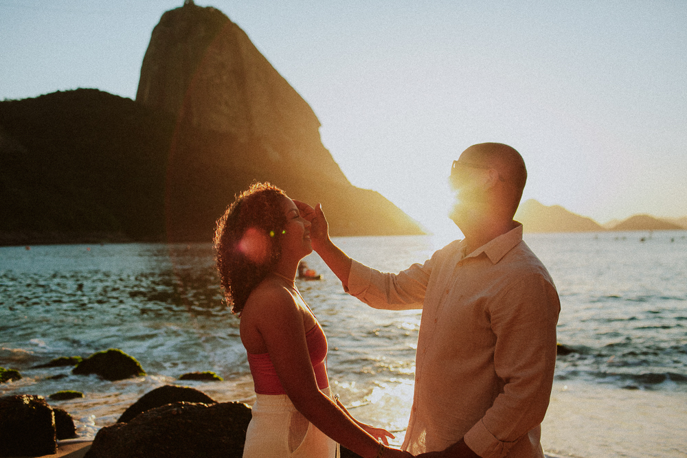 Pai e filha durante um momento de bênção no ensaio fotográfico de 15 anos de Alice na Praia Vermelha no nascer do sol