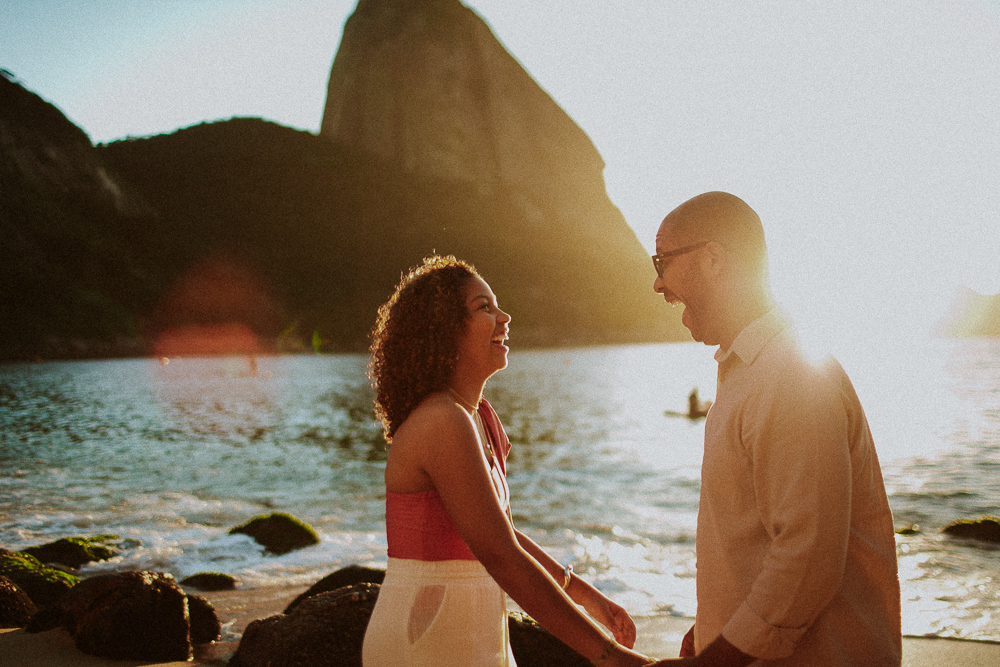 Alice e seu pai de mãos dadas durante ensaio de 15 anos na Praia Vermelha, diante do Pão de Açúcar durante amanhecer