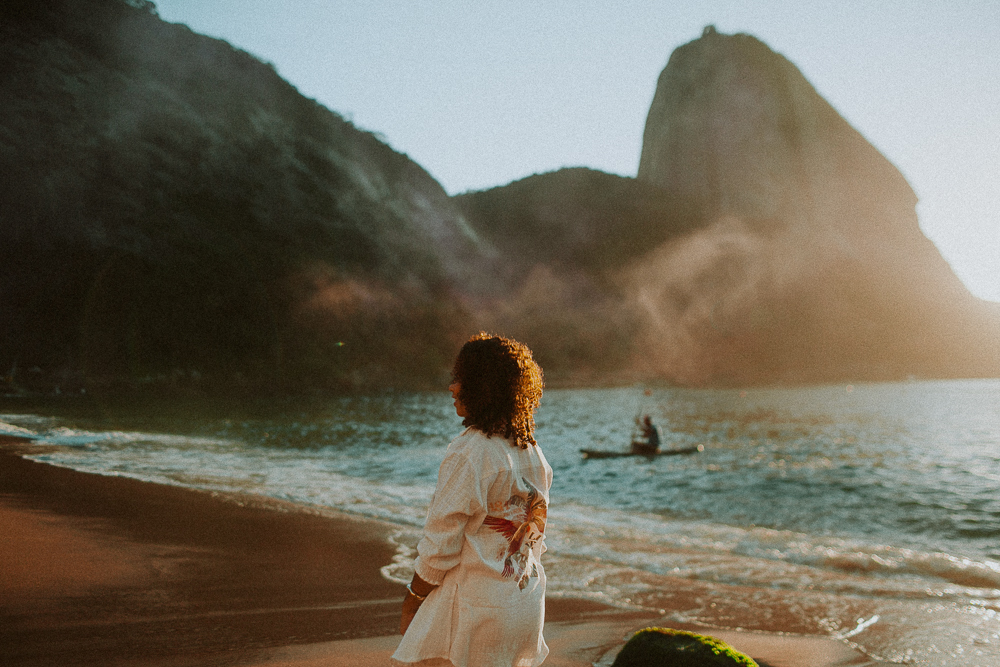 Alice caminhando à beira-mar durante seu ensaio fotográfico de 15 anos na Praia Vermelha, Rio de Janeiro no nascer do sol