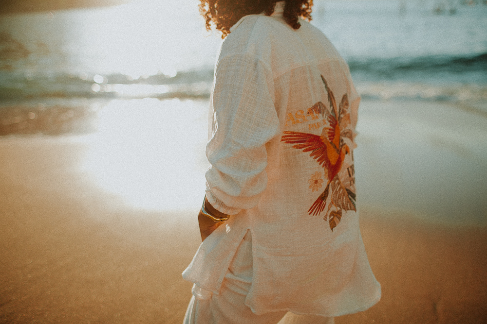 Detalhe de Alice caminhando na praia durante seu ensaio fotográfico de 15 anos, com a luz dourada do nascer do sol