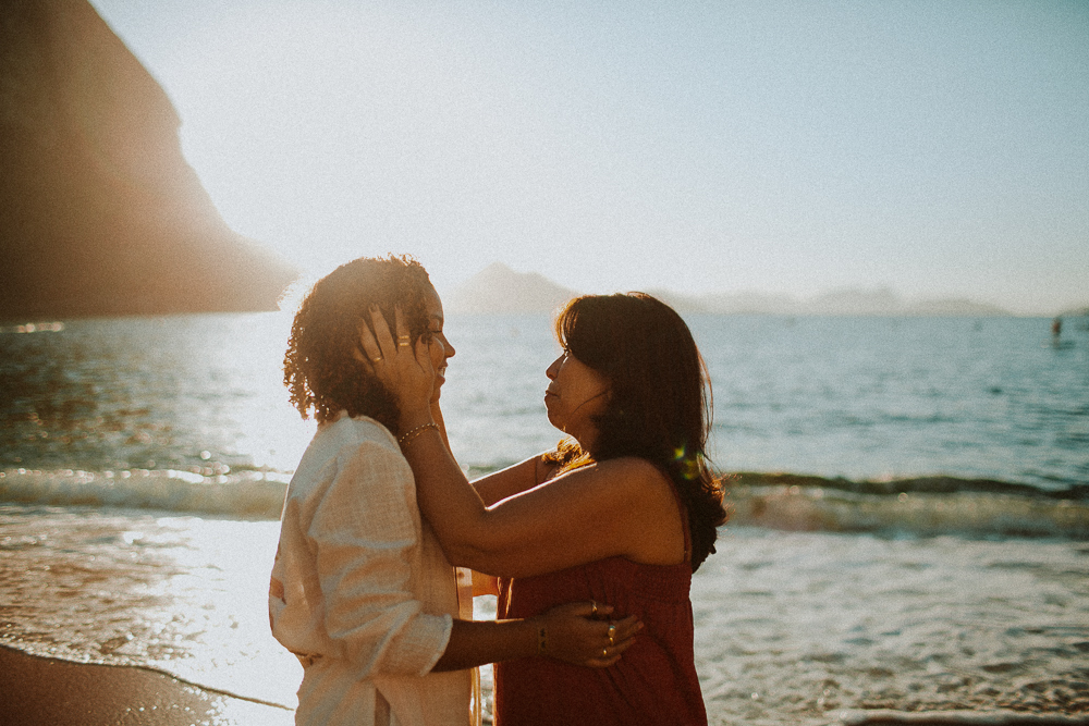 Alice e sua mãe em um momento de carinho durante ensaio fotográfico de 15 anos na Praia Vermelha, Rio de Janeiro.