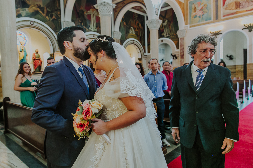 Noivos diante do altar durante a celebração do Sacramento do Matrimônio em casamento católico no Grajaú, Rio de Janeiro. Fotografia de casamento por Aline Lelles do Atelier Fotografia Afetiva. Paróquia Nossa Senhora do Perpétuo Socorro RJ