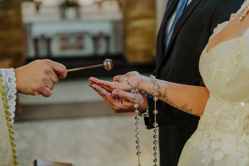Noivos diante do altar trocando alianças durante a celebração do Sacramento do Matrimônio em casamento católico no Grajaú, Rio de Janeiro. Fotografia de casamento por Aline Lelles do Atelier Fotografia Afetiva