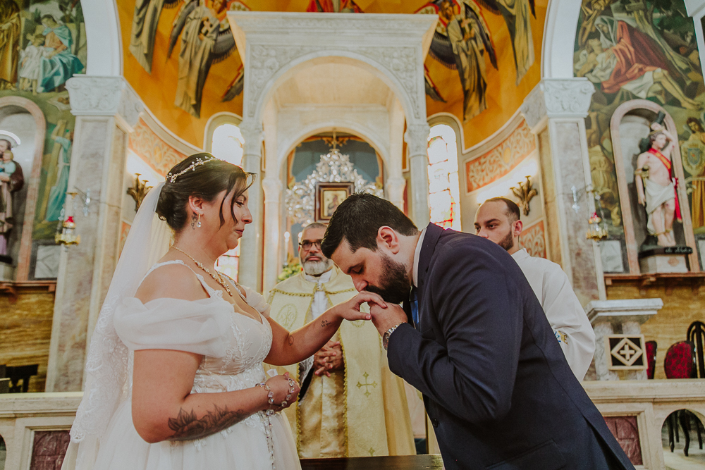 Noivos diante do altar trocando alianças durante a celebração do Sacramento do Matrimônio em casamento católico no Grajaú, Rio de Janeiro. Fotografia de casamento por Aline Lelles do Atelier Fotografia Afetiva